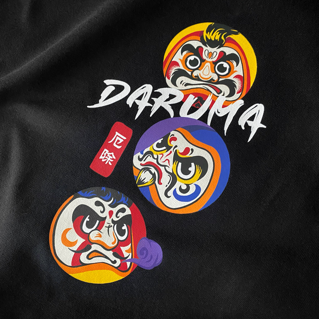 a close-up of the design of Japanese daruma printed on the black tank tops - anatta streetwear