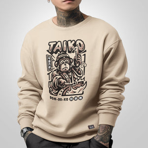 Taiko - a model wearing a khaki sweatshirt featuring a design of a monkey dressed in traditional Japanese clothing playing a taiko drum printed on the front