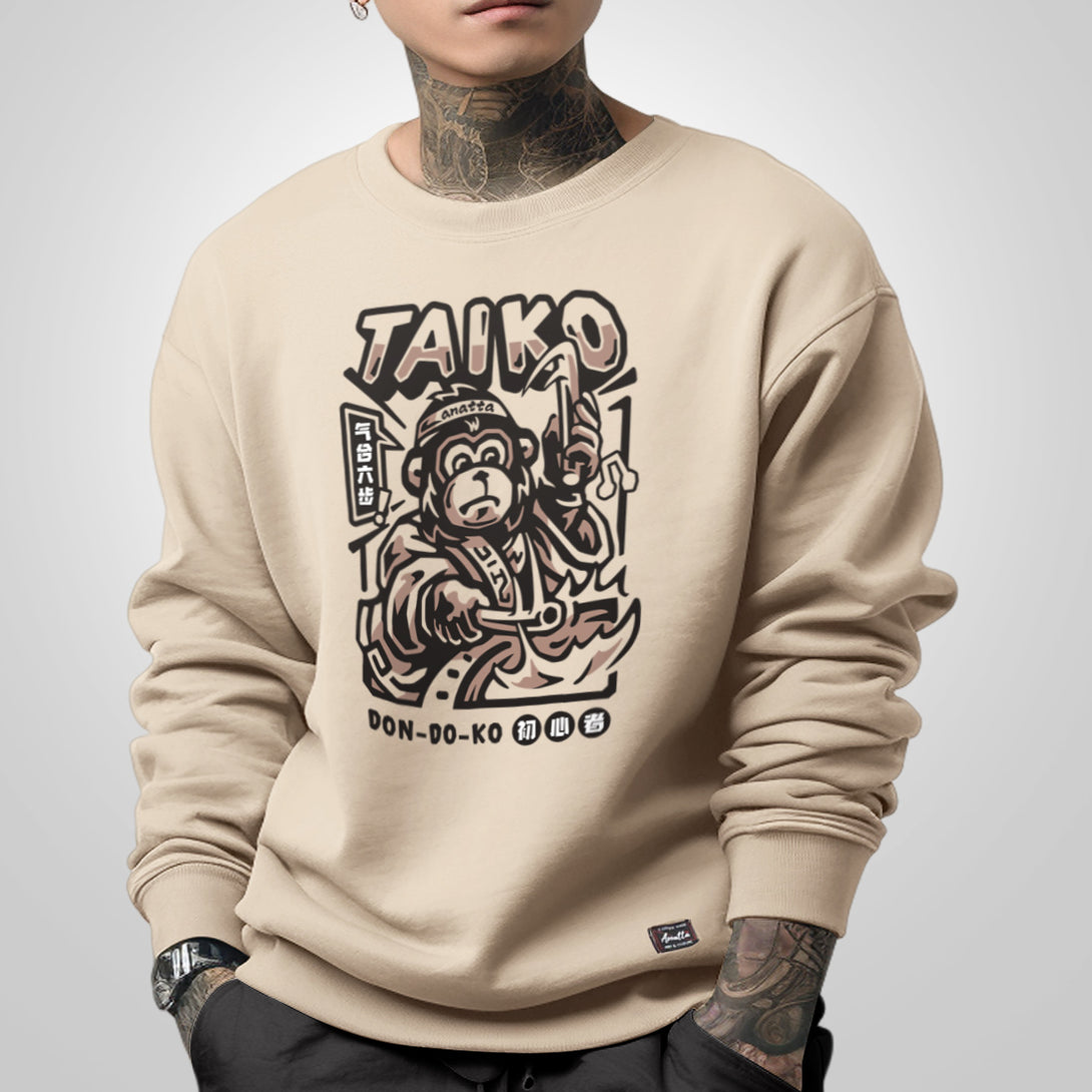 Taiko - a model wearing a khaki sweatshirt featuring a design of a monkey dressed in traditional Japanese clothing playing a taiko drum printed on the front 