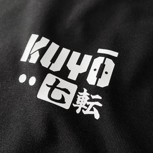 Daruma kuyō- a close-up of a text graphic design, printed on the left chest of a black sweatshirt