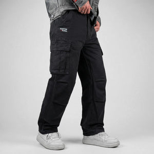 model wearing black cargo pants on a gray background - Anatta Streetwear