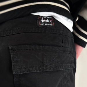 Black cargo pants with Anatta brand label on the pocket - Anatta Streetwear