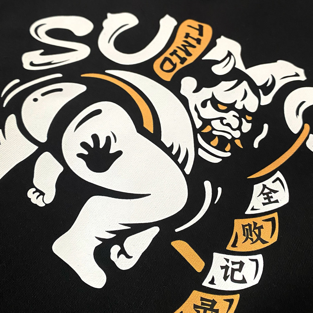 Timid Sumo - a close-up of a cute design of a timid sumo printed on the right of a black shorts-2