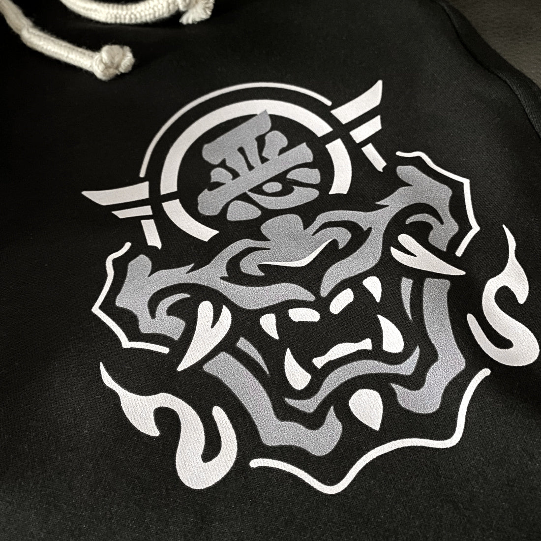 Hannya Mask - a close-up of the design of the Japanese Hannya mask, printed on the left of a black shorts