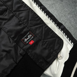 Close-up of the Raijin’s Wrath Japanese satin jacket interior, showing the quilted lining, inner pocket, zipper, and Anatta woven label