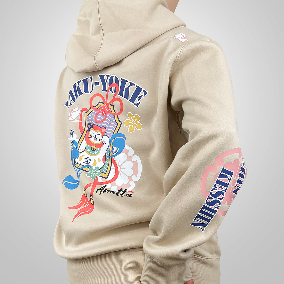 Omamori - a model wearing a khaki hoodie with a brightly colored illustration of a traditional Japanese good luck charm printed on the back-back view-1