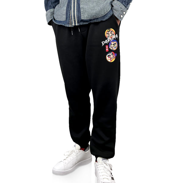 Daruma - a model wearing a Japanese style black sweatpants featuring the design of Japanese daruma, printed on the left