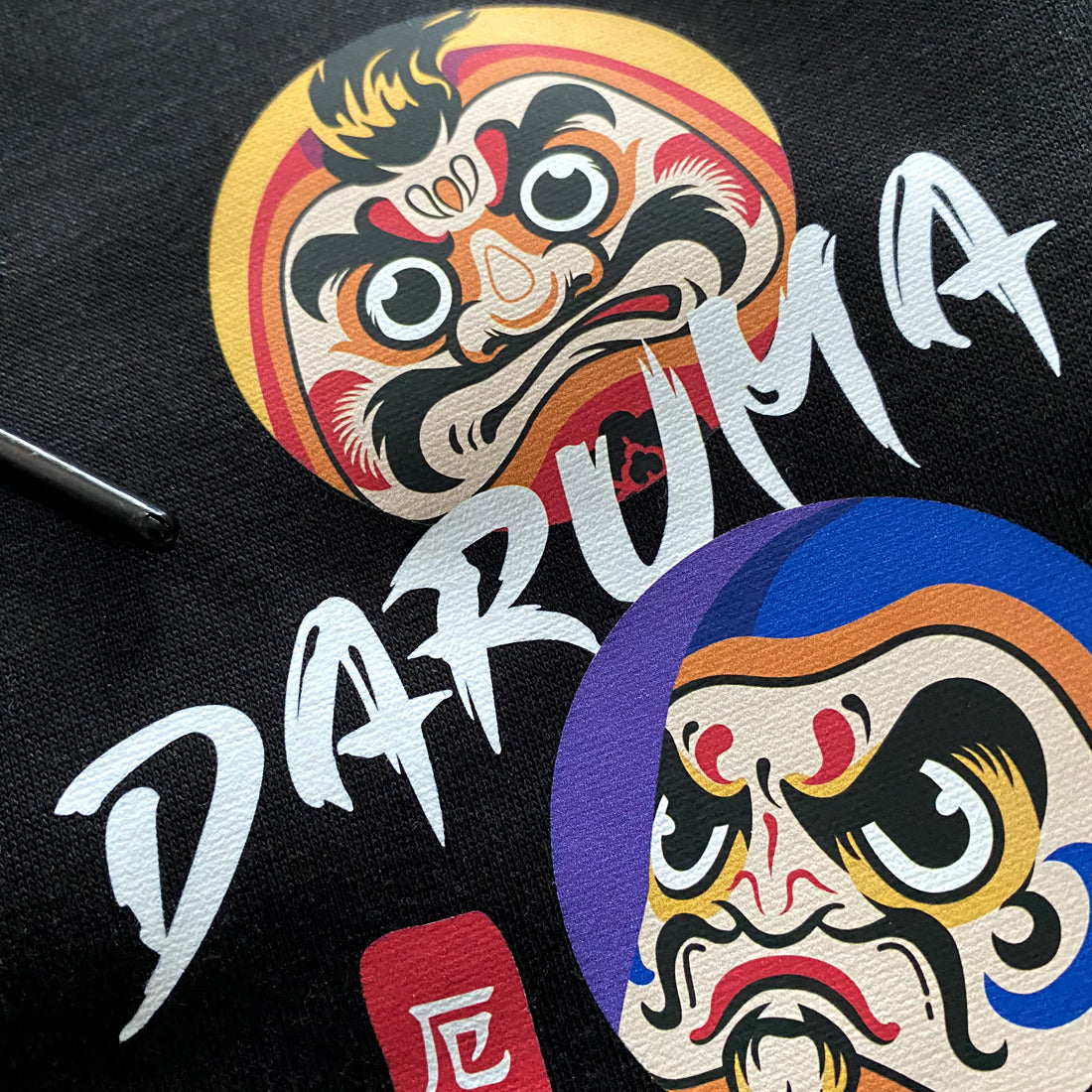 Daruma - a close-up of the design of Japanese daruma printed on the Japanese style black sweatpants-1
