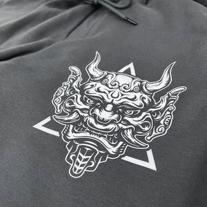 Sins Exist In Human Minds - a close-up of a design inspired by Japanese Oni masks, printed on the left of a Japanese style dark grey sweatpants