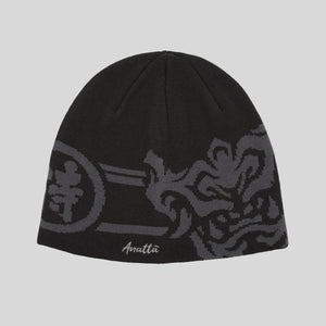 Black beanie with gray patterns and 'Anatta' branding on a light gray background