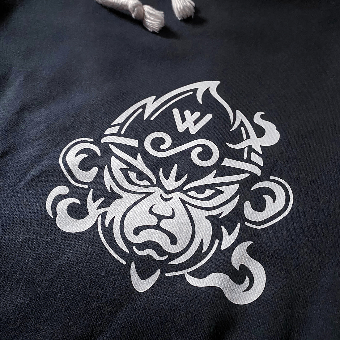 a close-up of a design of the great sage wukong, printed on the left of a black shorts - anatta streetwear