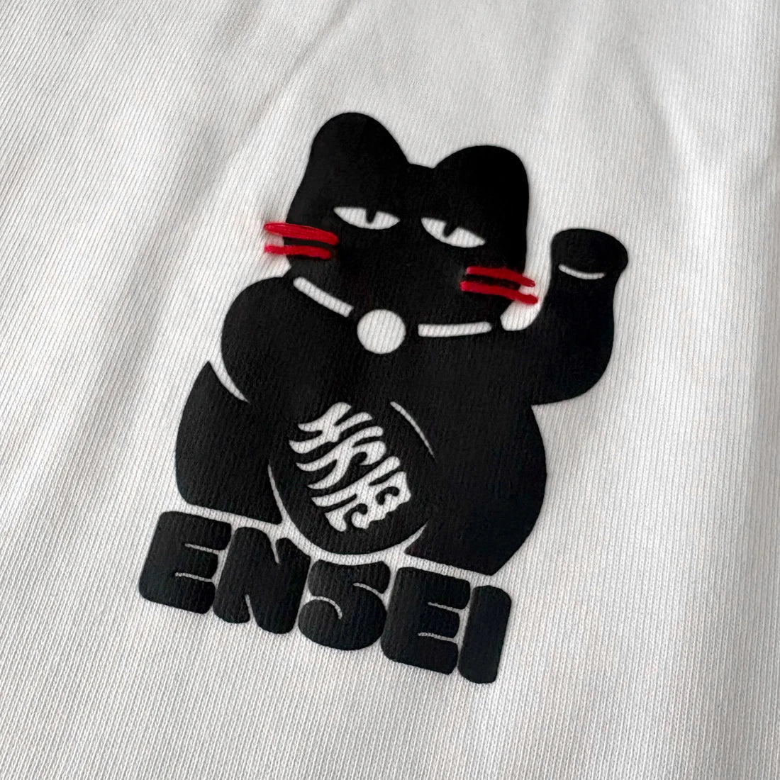 Close-up of Japanese-inspired lucky cat graphic on chest – Anatta