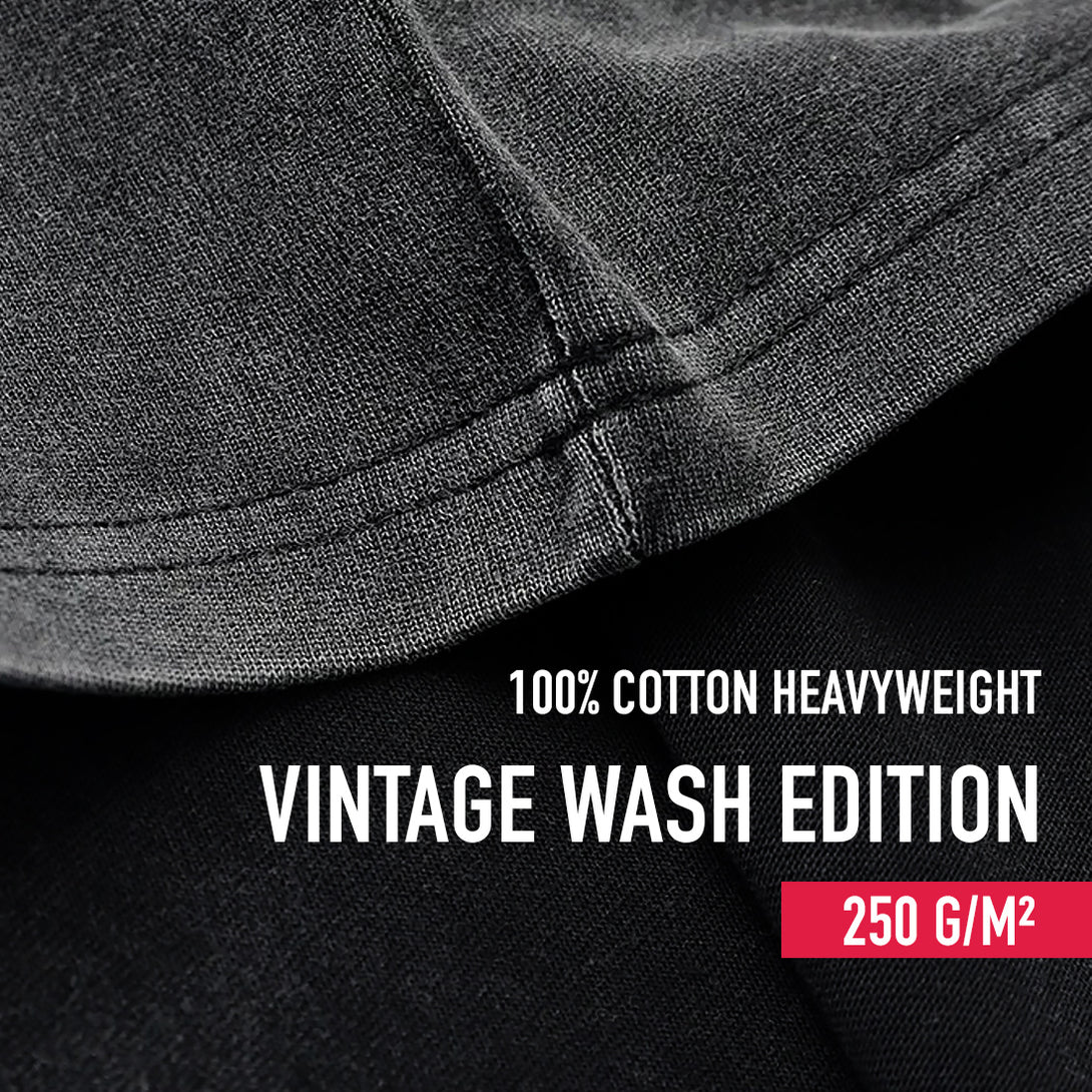 Close-up of a vintage black fabric with '100% Cotton Heavyweight Vintage Wash Edition' text and weight information.