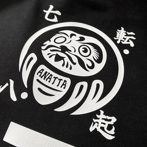 Daruma kuyō - a close-up of the design of daruma doll, printed on the back of a black sweatshirt 