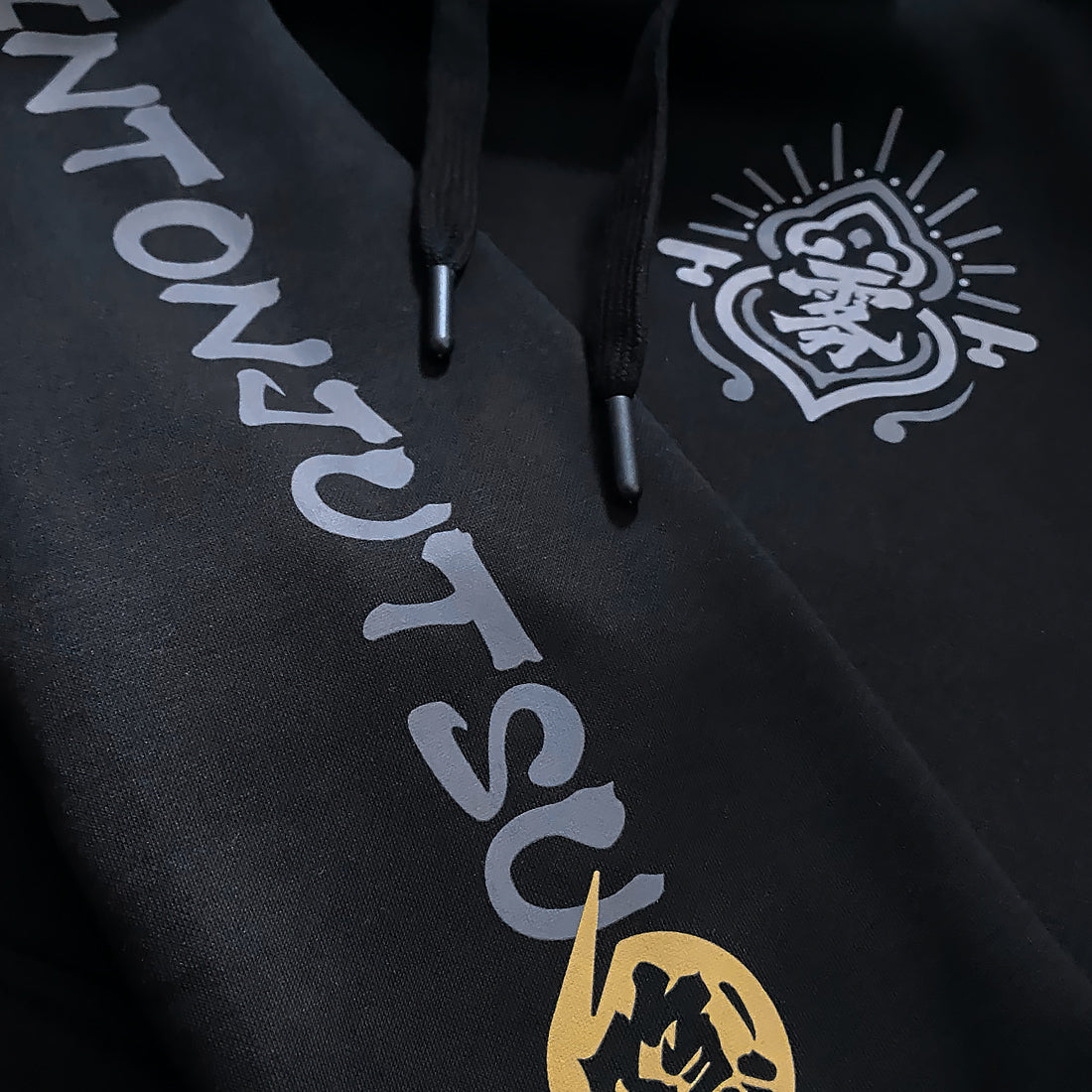 a close-up of the graphic design on a Japanese style black hoodie sleeve