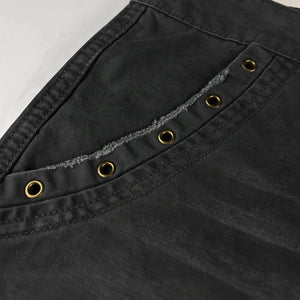 Close-up of black pants with gold buttons and stitching details - Anatta Streetwear