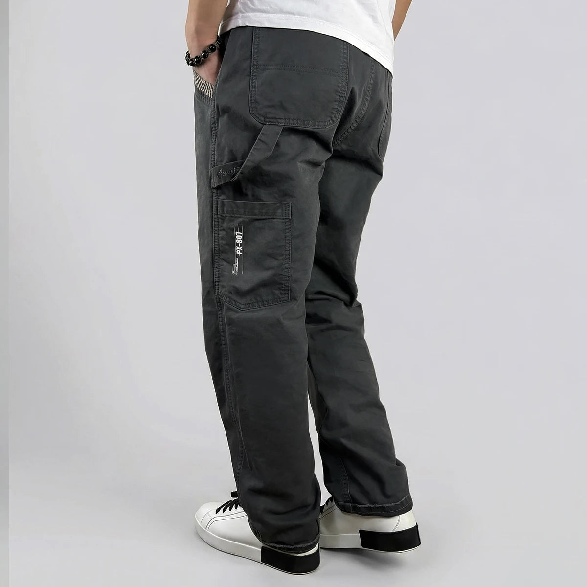 model wearing dark gray cargo pants on a plain background - Anatta Streetwear