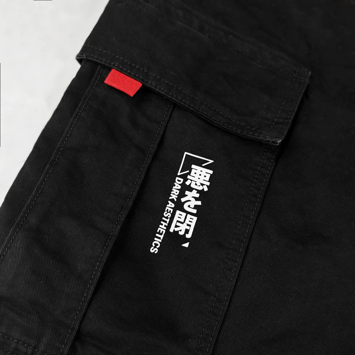 Black cargo pants with a red tag and white text on a white background - Anatta Streetwear