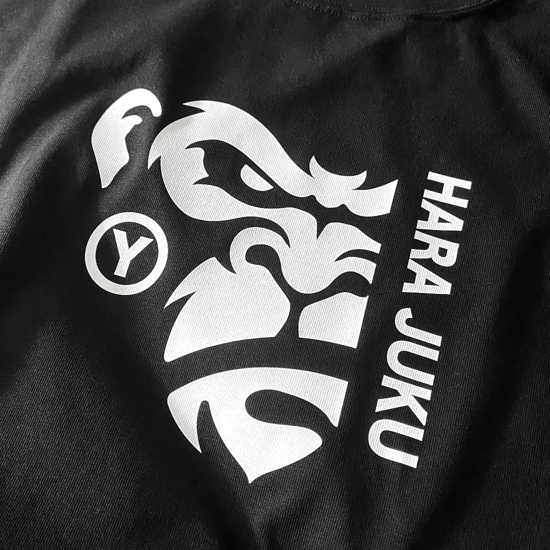 a close-up of a graphic design of the angry ape, printed on the front of a black heavyweight T-shirt - Anatta Streetwear