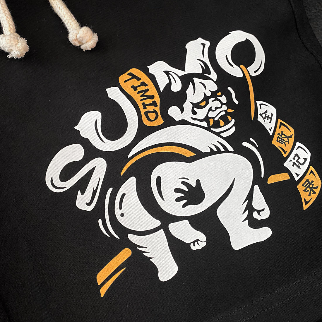 Timid Sumo - a close-up of a cute design of a timid sumo printed on the right of a black shorts-1