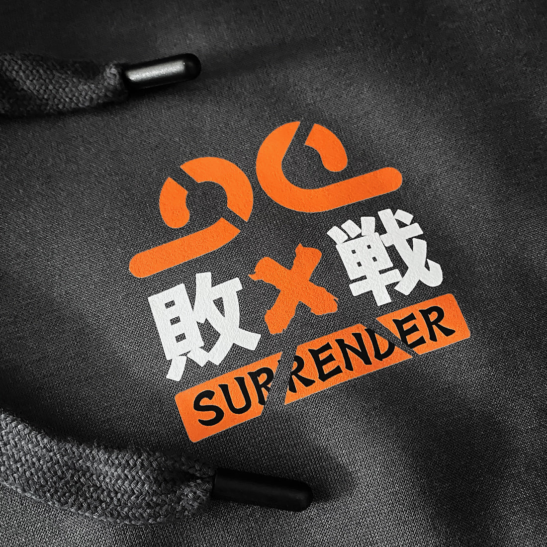 a close-up of a small graphic design, printed on the left chest of the Japanese style dark grey hoodie - Anatta Streetwear