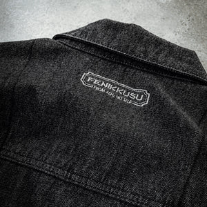 Close-up of the Fenikkusu embroidered back-neck logo on the dark grey Japanese denim jacket