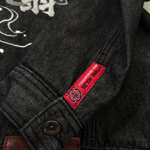 Close-up of red woven label and stitching details on the Fenikkusu dark grey Japanese denim jacket