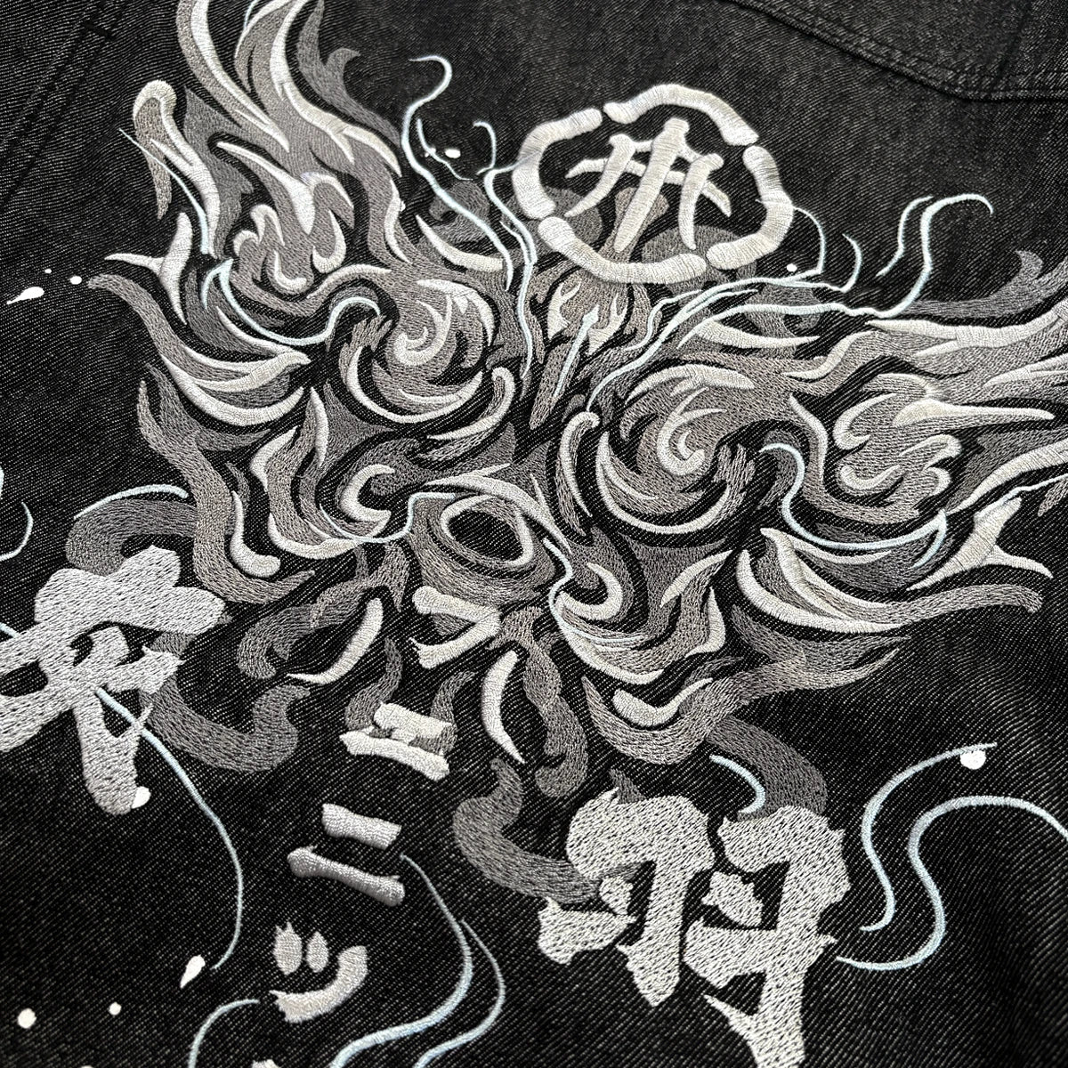 Close-up of phoenix embroidery on the Fenikkusu dark grey Japanese denim jacket