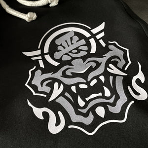 Hannya Mask - a close-up of the design of the Japanese Hannya mask, printed on the left of a black shorts