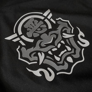 a graphic design of the Japanese Hannya mask, printed on the front of a black tank top
