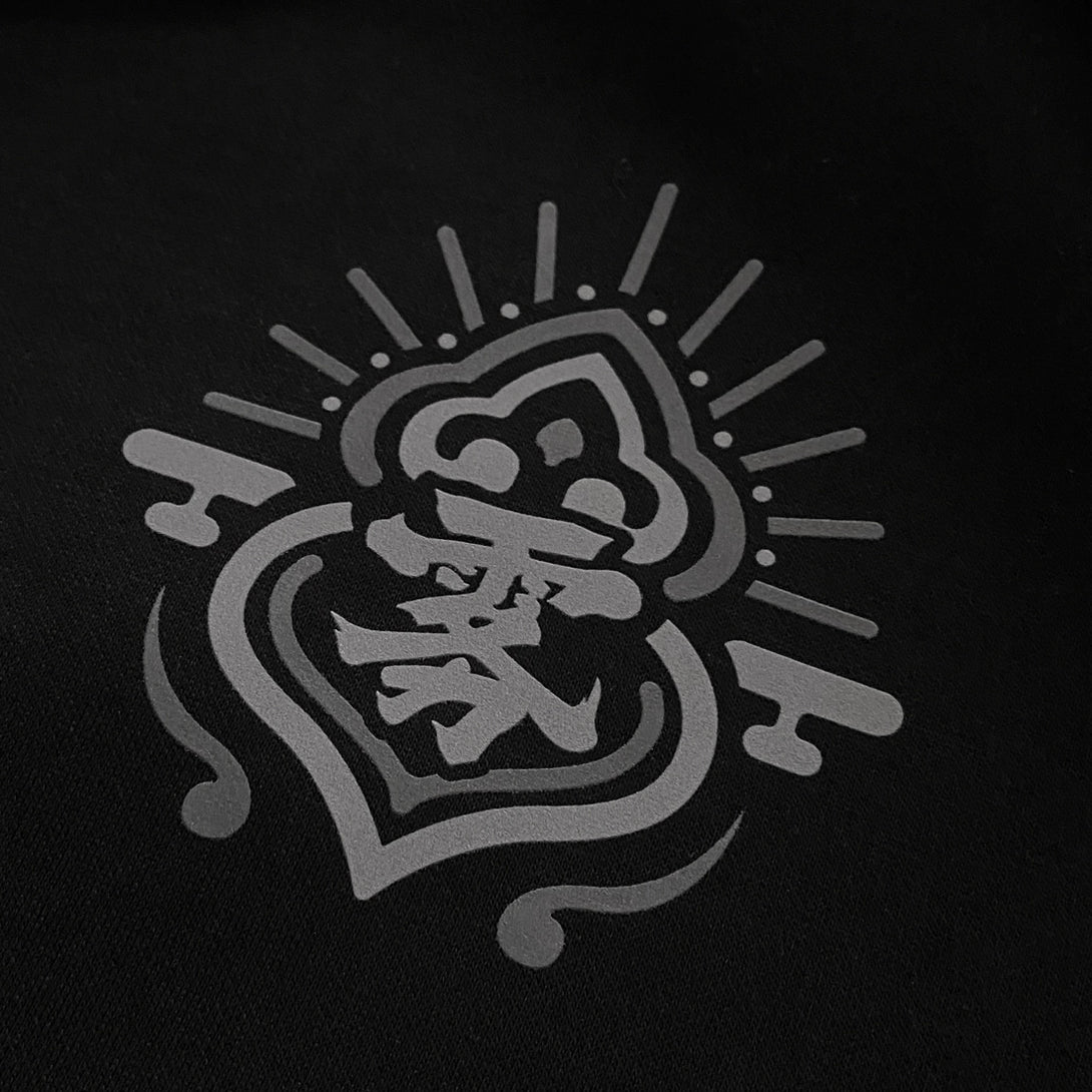 a close-up of a small graphic design, printed on the left chest of the Japanese style black sweatshirt - Anatta Streetwear