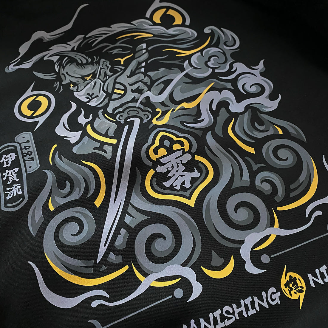The close-up of a graphic design inspired by Intonjutsu (art of vanishing), printed on the back of a Japanese style hoodie - Anatta Streetwear