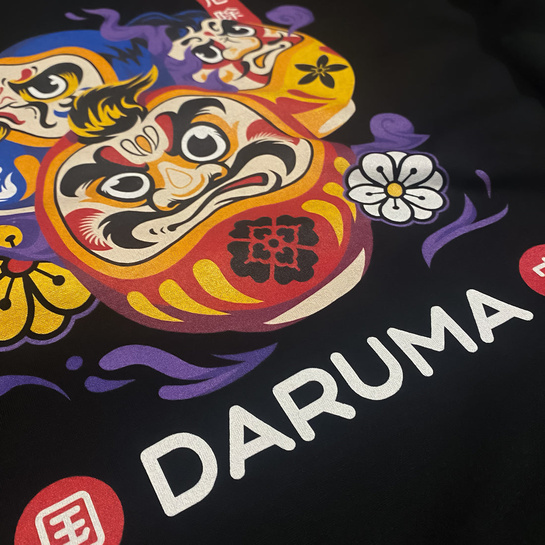 Daruma - a close-up of a graphic design of Japanese drama doll, printed on the front of a Japanese style black heavyweight sweatshirt-1