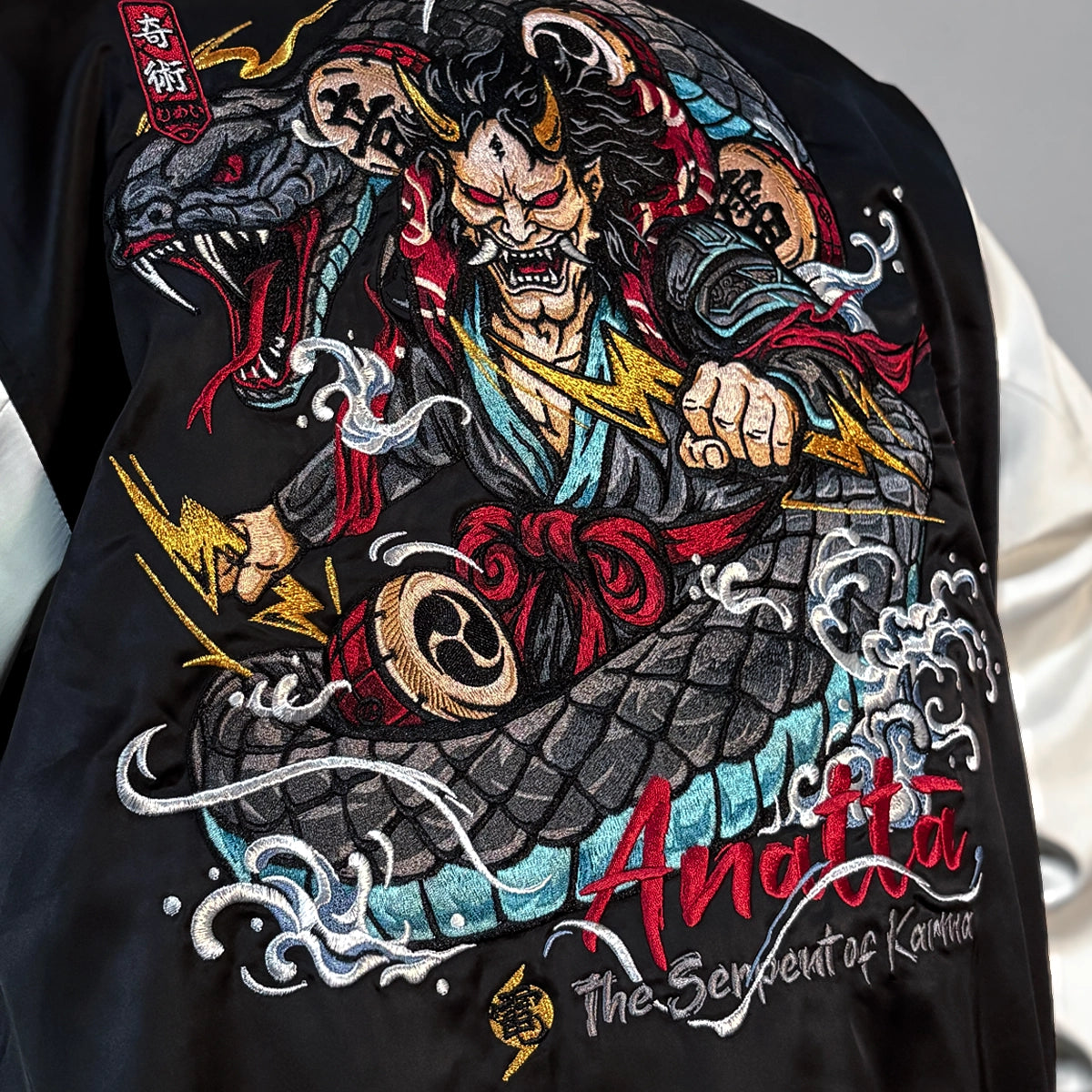 Close-up of the Raijin’s Wrath Japanese satin jacket back embroidery, showing Raijin, the serpent, thunder drums, lightning, and waves
