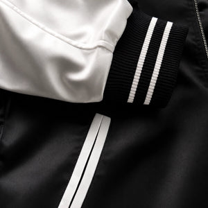 Close-up of the Raijin’s Wrath Japanese satin jacket, showing the striped ribbed cuff, satin sleeve, and contrast-trimmed pocket