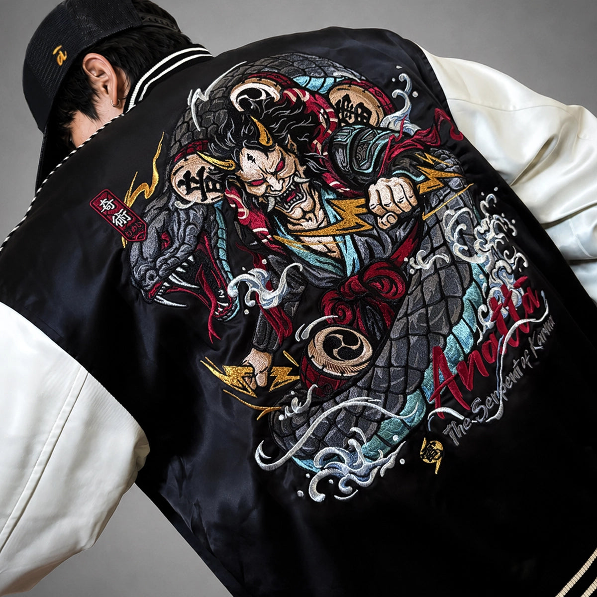 A model wearing the Raijin’s Wrath Japanese satin jacket, close-up back view highlighting the oversized Raijin and serpent embroidery