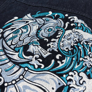 Close-up of the Rogue Wave denim jacket showing high-density Japanese wave embroidery in white and teal.