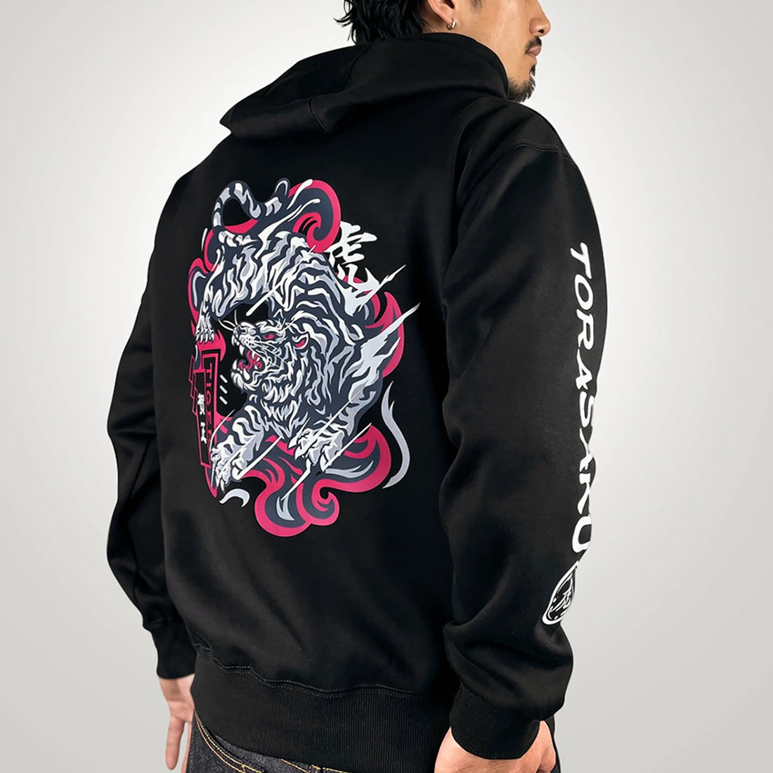 The tiger- a model wearing a black hoodie with the intricate illustration of a fierce Japanese tiger printed on the back-back view-2