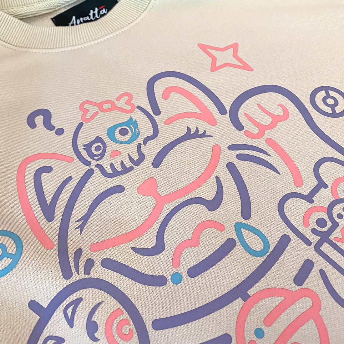 Not to believe in luck- a close-up of a Japanese luck cat design printed on the front of a khaki sweatshirt-1