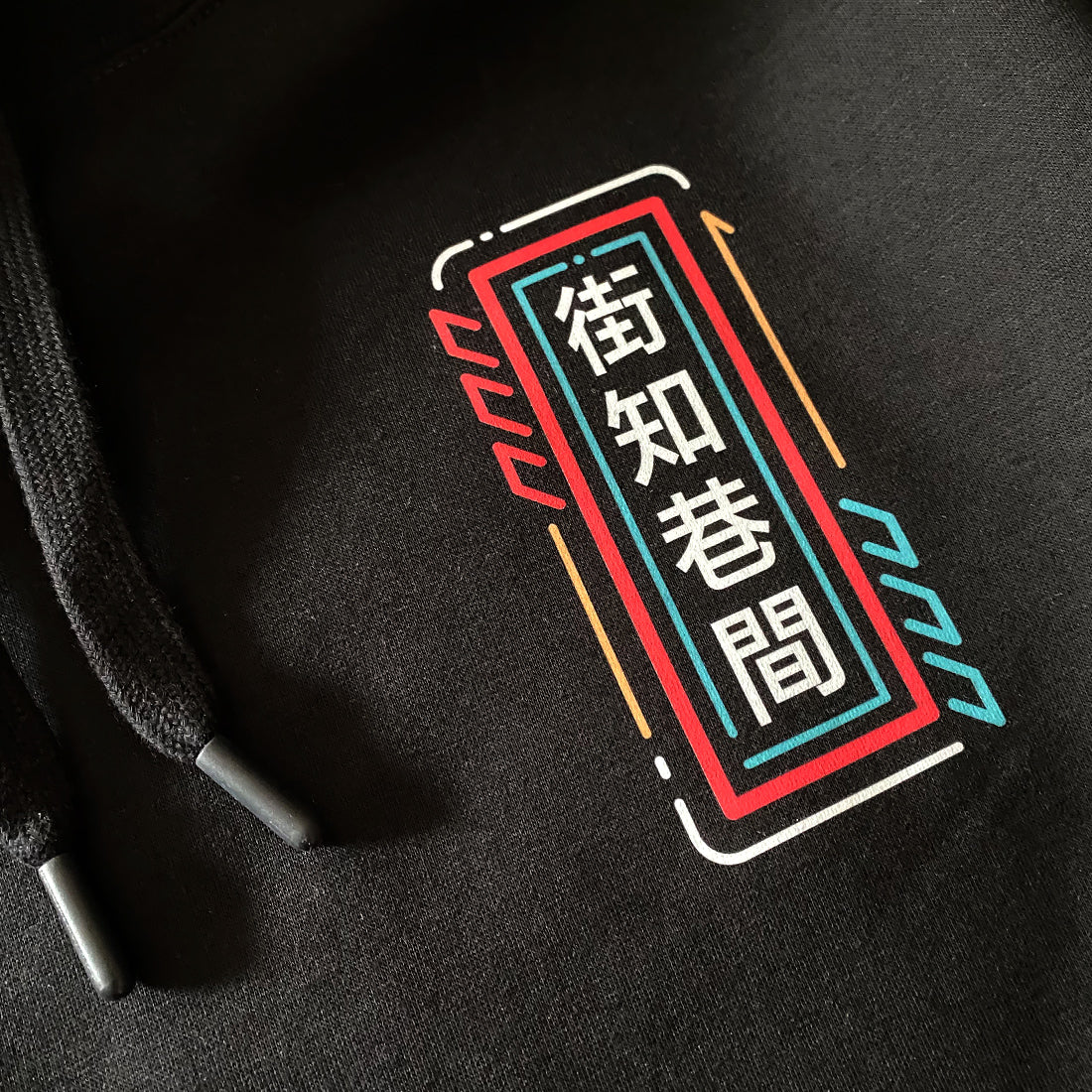 Neon - a close-up of the graphic design printed on the front of the Japanese style black hoodie