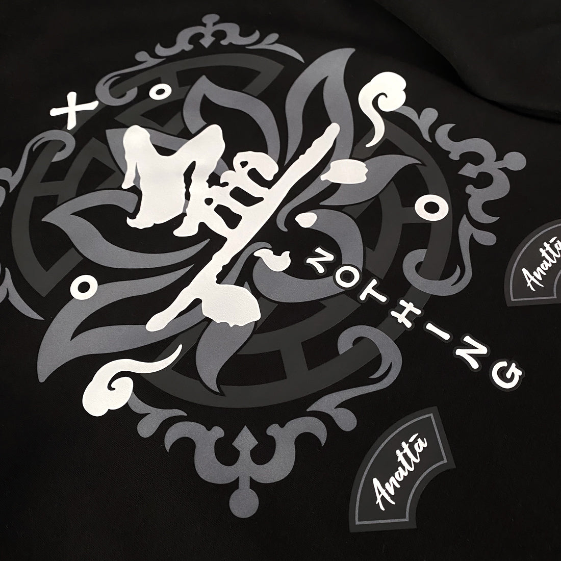 Emptiness - a close-up of the design with a background of religious patterns, overlaid with the Chinese character WU (meaning emptiness) , printed on the back of the black sweatshirt.