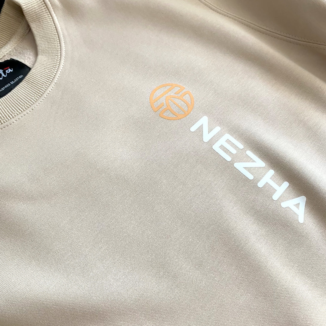 Nezha - a close-up of the word Nezha and an accompanying icon, printed on the left front of the khaki sweatshirt.