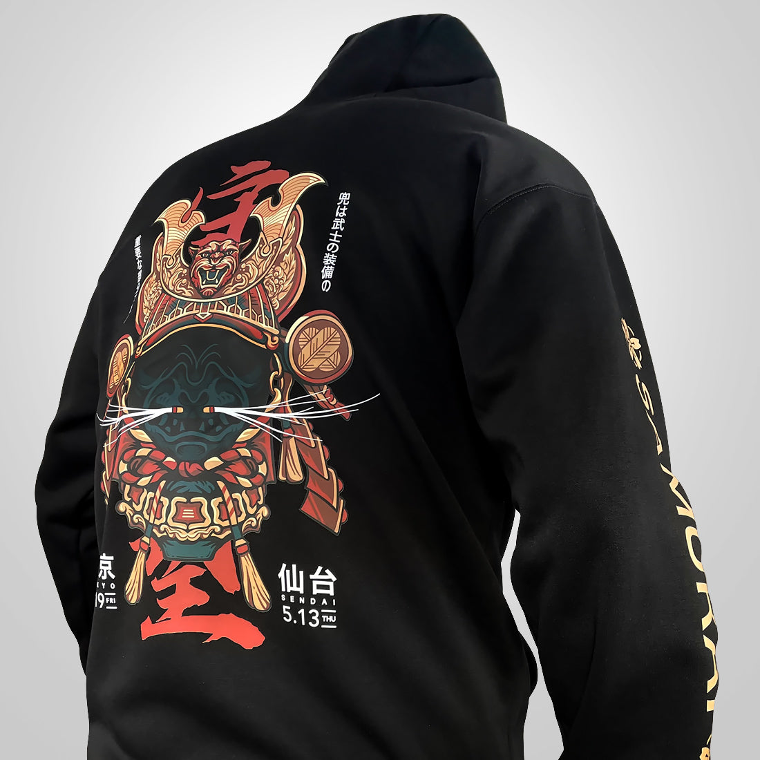 Kabuto - a model wearing a black hoodie with the intricate illustration of a Japanese samurai helmet printed on the back-back view-1
