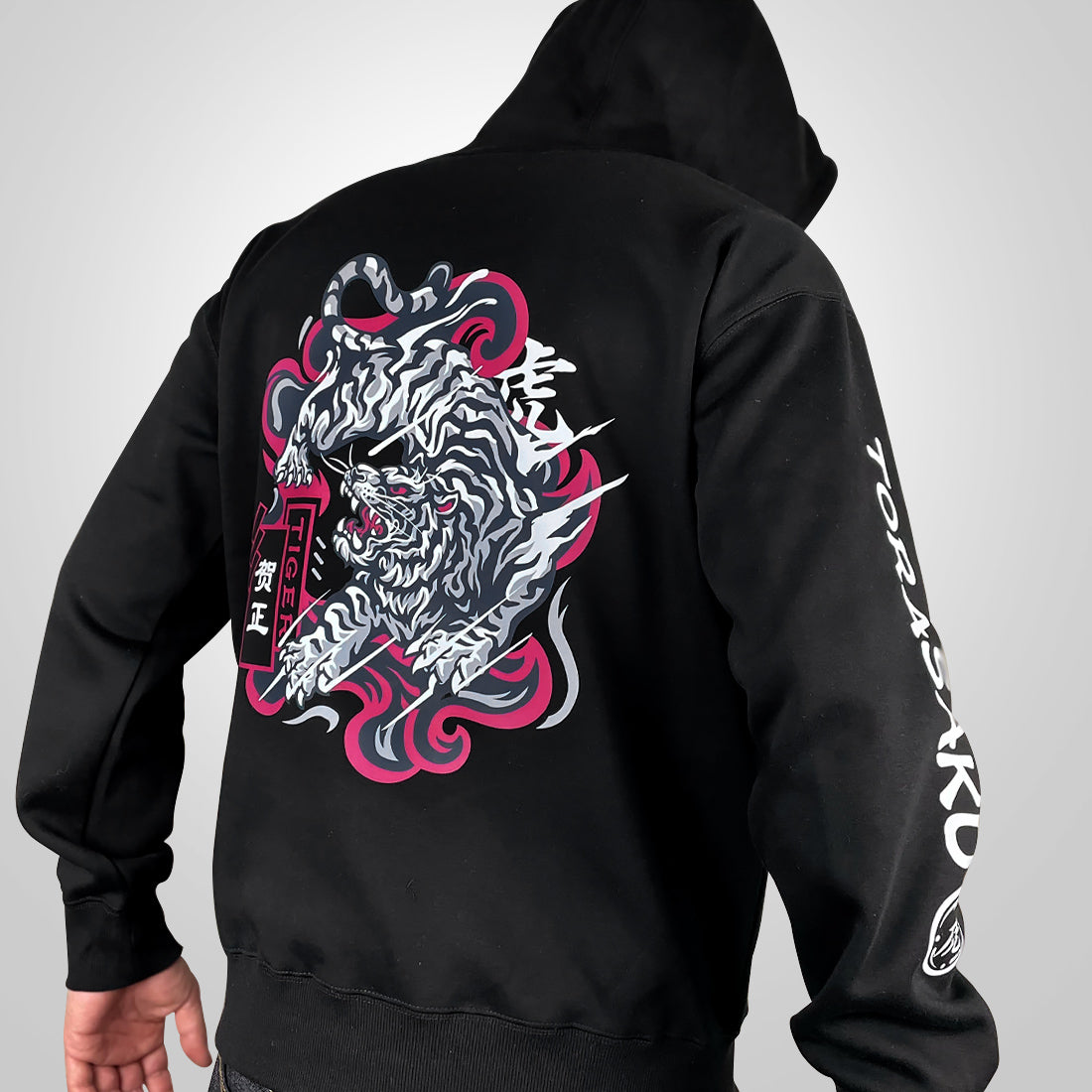 The tiger- a model wearing a black hoodie with the intricate illustration of a fierce Japanese tiger printed on the back-back view-1