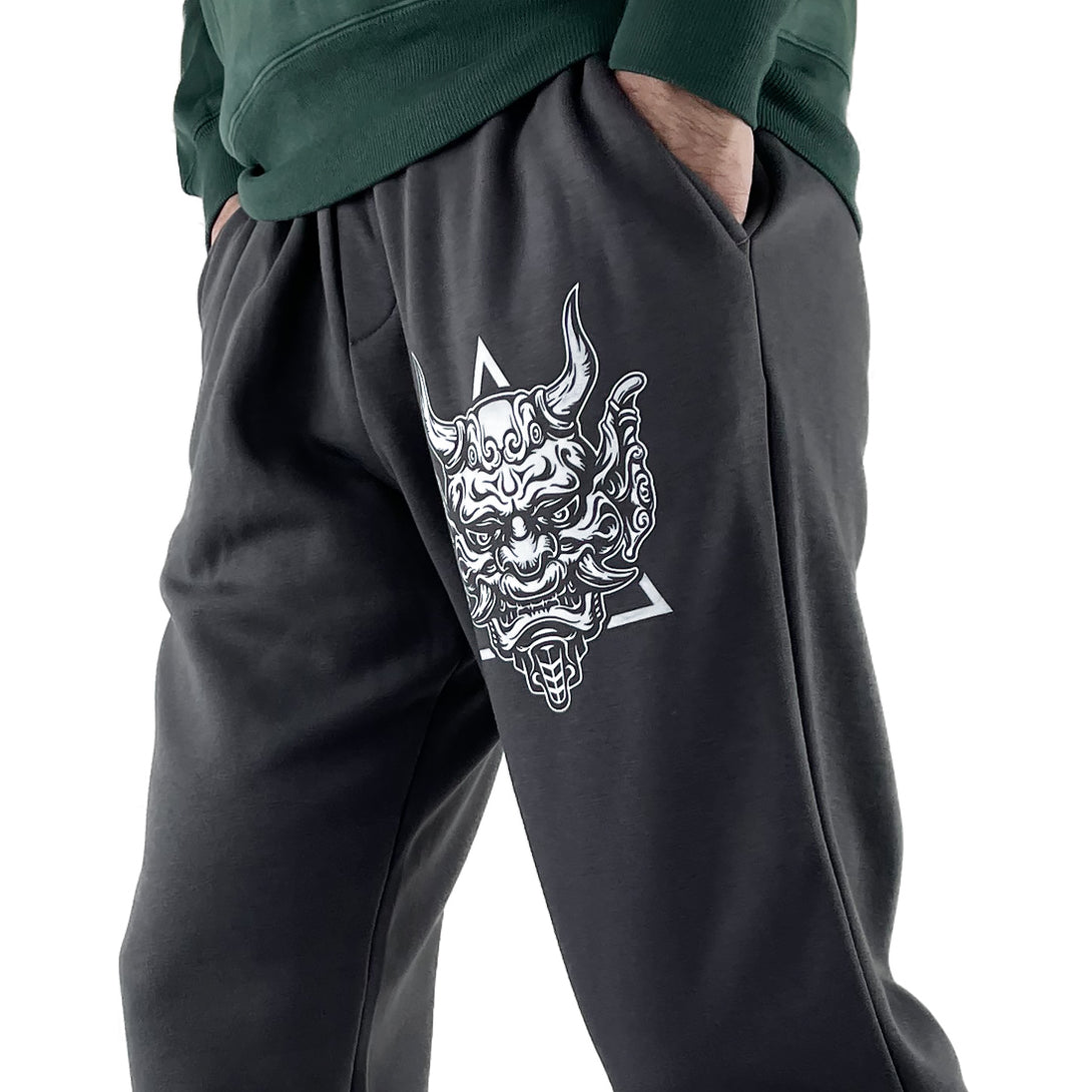 Sins Exist In Human Minds  - a model wearing a Japanese style dark grey sweatpants featuring a design inspired by Japanese Oni masks, printed on the left-2