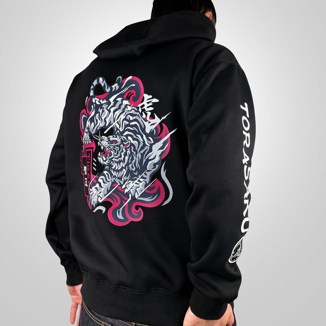 The tiger- a model wearing a black hoodie with the intricate illustration of a fierce Japanese tiger printed on the back-back view-2